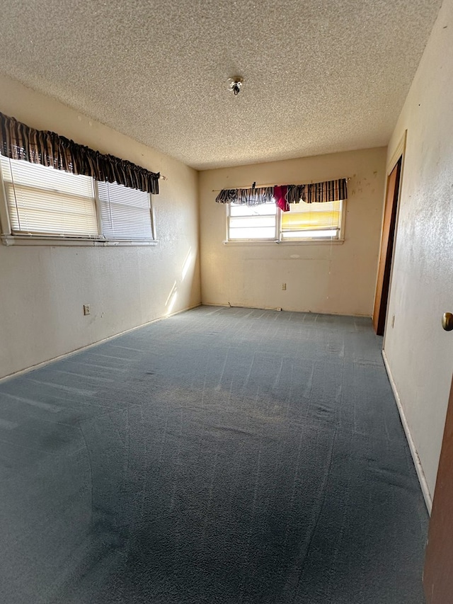 carpeted spare room with a textured ceiling