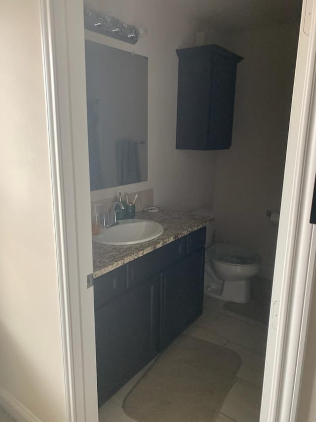 bathroom featuring tile patterned floors, vanity, and toilet