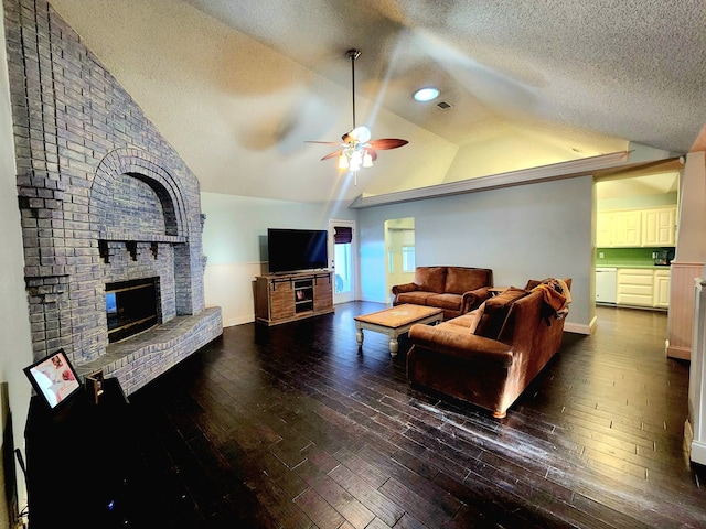 living room with vaulted ceiling, a fireplace, a textured ceiling, and hardwood / wood-style floors