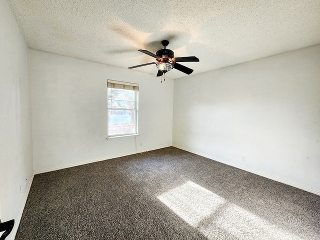 carpeted spare room with a textured ceiling, baseboards, and a ceiling fan