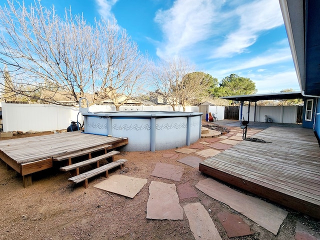 view of yard featuring a deck, an outbuilding, fence, a fenced in pool, and a storage unit