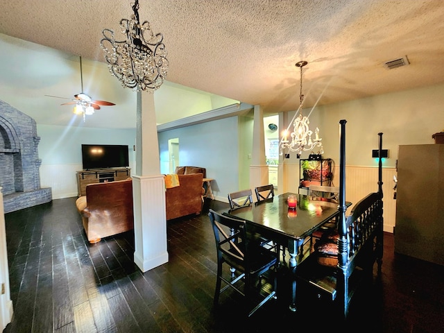 dining area with visible vents, wainscoting, lofted ceiling, wood-type flooring, and a textured ceiling