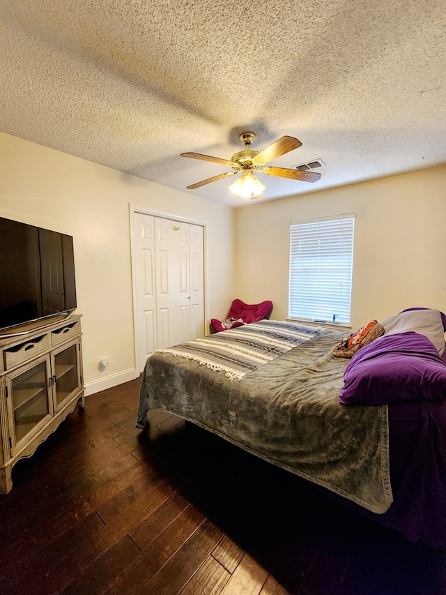 bedroom featuring ceiling fan, visible vents, baseboards, a closet, and wood-type flooring