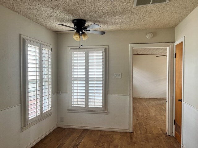 interior space with ceiling fan, dark wood-type flooring, and a textured ceiling