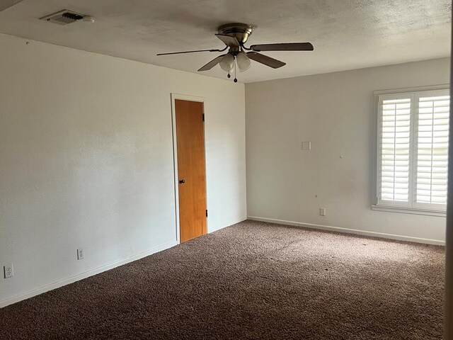 carpeted empty room with ceiling fan and a textured ceiling