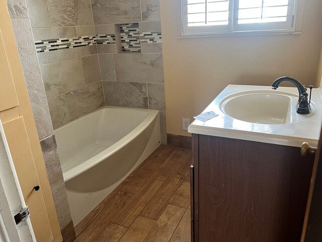 bathroom featuring vanity, hardwood / wood-style floors, and a bathtub