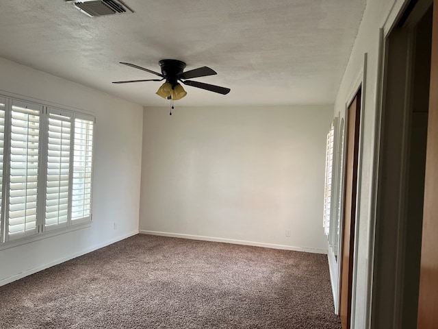 carpeted spare room with ceiling fan and a textured ceiling