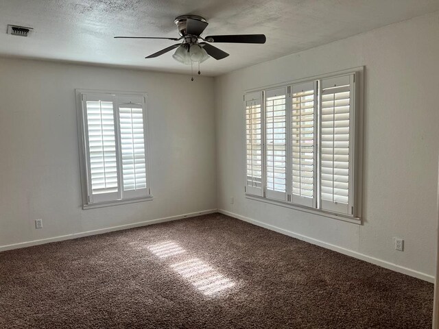 carpeted empty room featuring a textured ceiling and ceiling fan