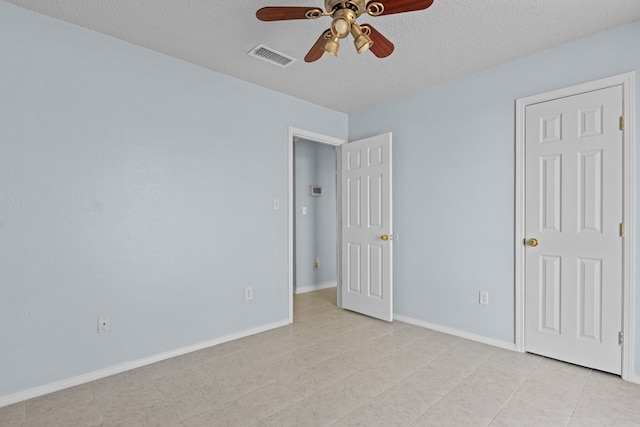 unfurnished bedroom with ceiling fan and a textured ceiling