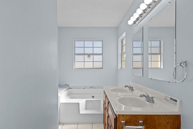 bathroom with vanity, a bathtub, and a textured ceiling