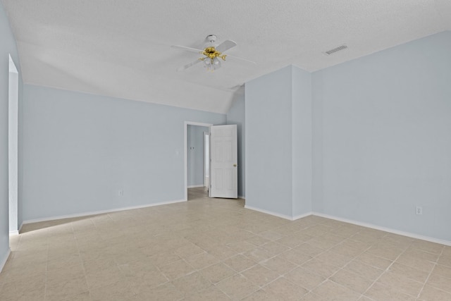 spare room featuring ceiling fan, vaulted ceiling, and a textured ceiling