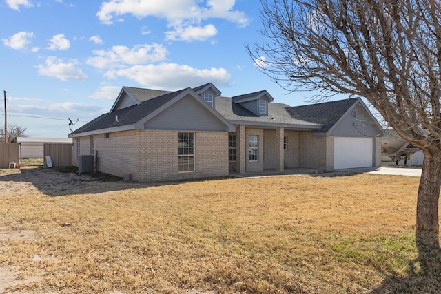 view of front of home featuring a garage, a front yard, and cooling unit