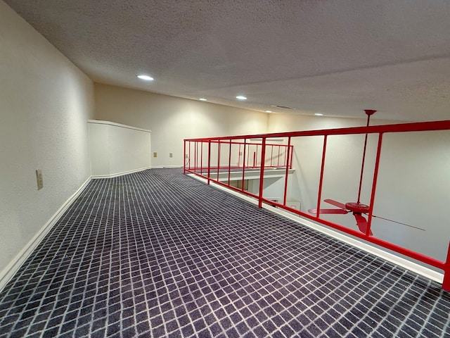 hall with vaulted ceiling, carpet flooring, and a textured ceiling