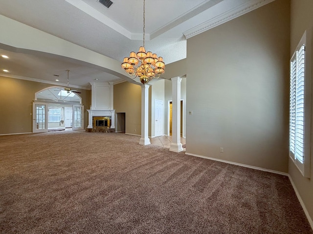 unfurnished living room featuring crown molding, plenty of natural light, a large fireplace, light colored carpet, and ornate columns