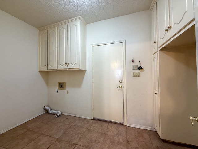 clothes washing area with hookup for a washing machine, cabinets, a textured ceiling, and hookup for an electric dryer