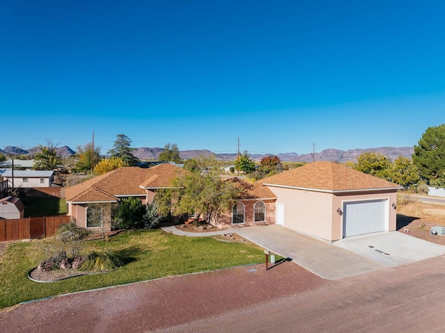 view of front of home with a mountain view, a garage, and a front yard