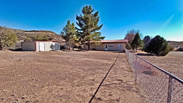 exterior space with a storage unit, an outdoor structure, and fence