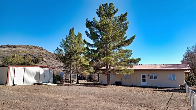 exterior space with an outdoor structure, a tile roof, and stucco siding