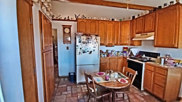 kitchen featuring electric stove, brown cabinets, freestanding refrigerator, light countertops, and under cabinet range hood