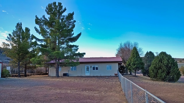 exterior space featuring cooling unit, fence, and stucco siding