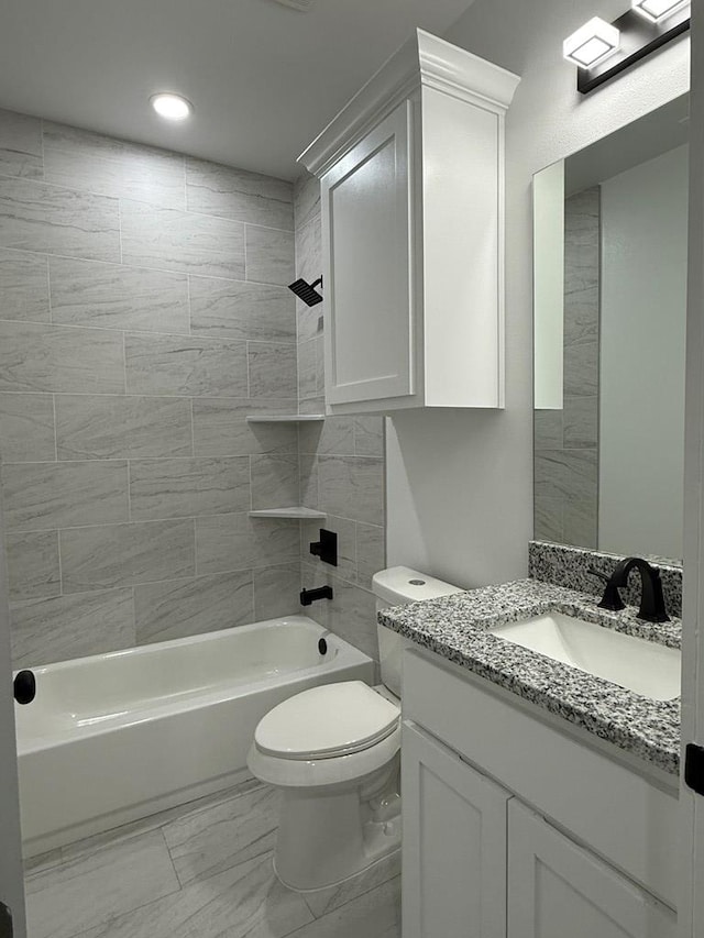 full bathroom with vanity, tiled shower / bath combo, and toilet