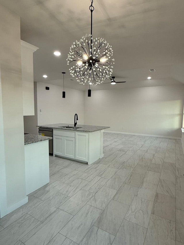 kitchen with white cabinetry, dishwasher, sink, hanging light fixtures, and light stone countertops