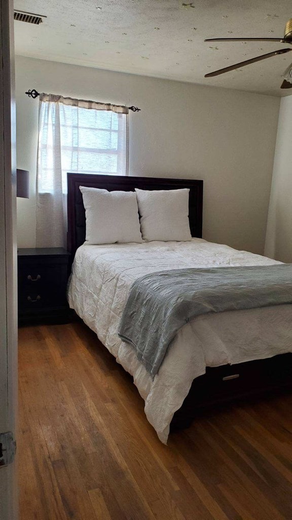 bedroom with wood-type flooring and ceiling fan