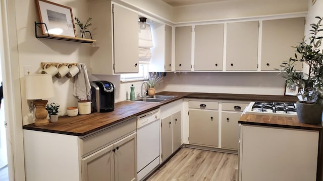 kitchen featuring sink, butcher block countertops, white cabinetry, white appliances, and light hardwood / wood-style floors