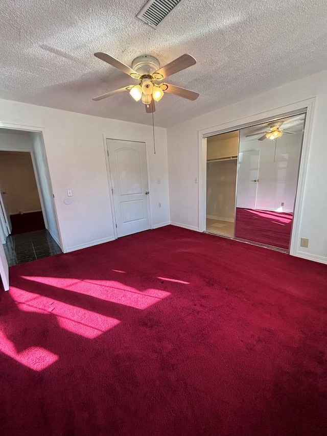 unfurnished bedroom with ceiling fan, carpet floors, a textured ceiling, and a closet