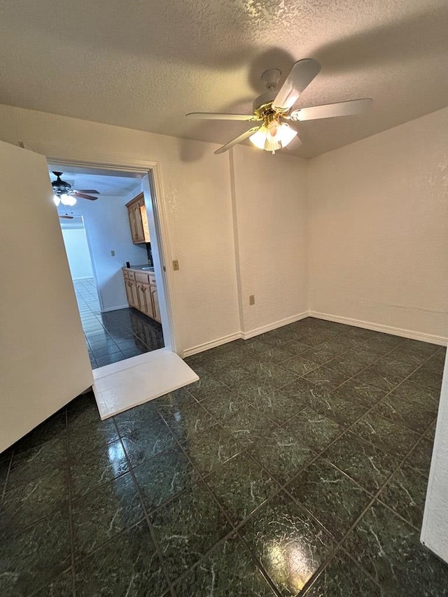 spare room featuring ceiling fan and a textured ceiling