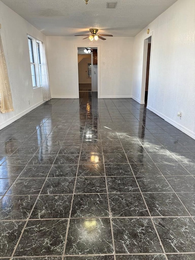 empty room featuring a textured ceiling and ceiling fan