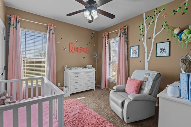 bedroom with a crib, carpet, and ceiling fan