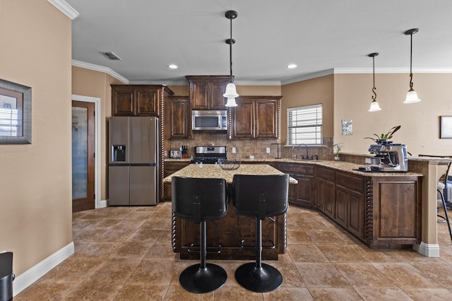 kitchen with stainless steel appliances, a kitchen island, hanging light fixtures, and dark brown cabinetry