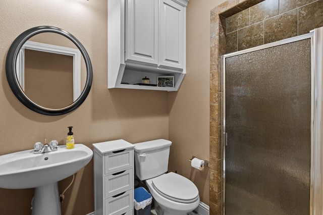 bathroom with sink, an enclosed shower, and toilet