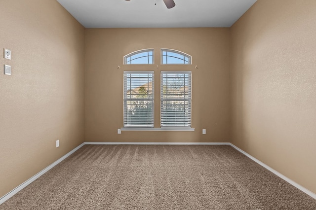 carpeted spare room with ceiling fan