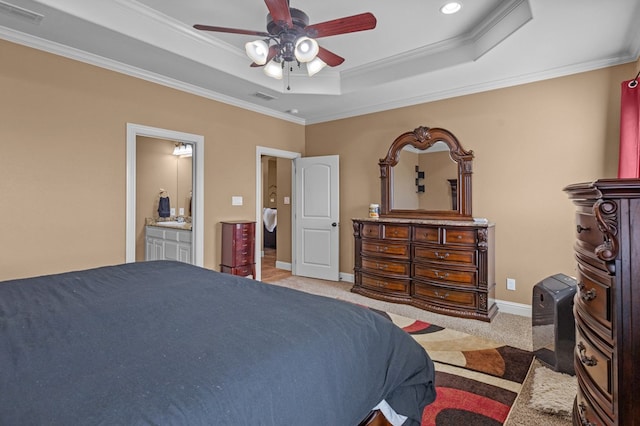 bedroom with ornamental molding, light carpet, ceiling fan, and a tray ceiling