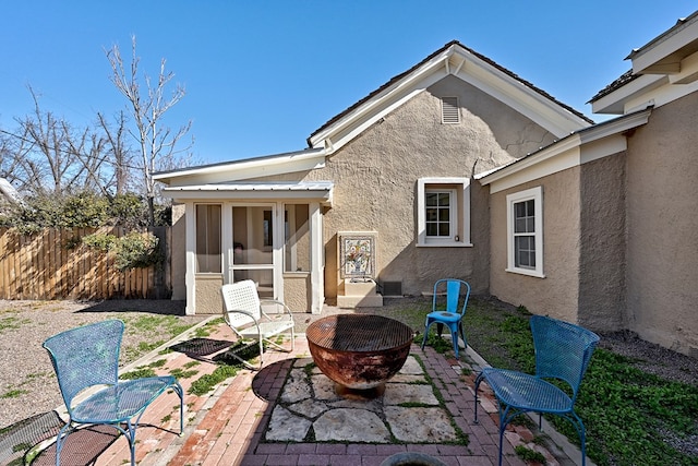 view of patio / terrace featuring an outdoor fire pit and a sunroom