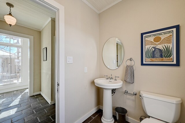 bathroom featuring toilet and crown molding