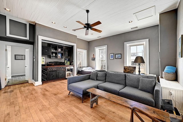 living room featuring ceiling fan, light hardwood / wood-style floors, and wine cooler