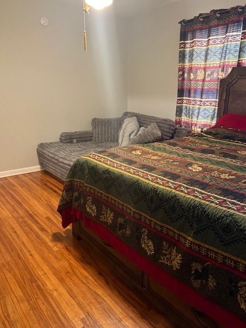 bedroom with baseboards and wood finished floors