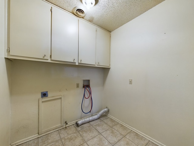 laundry room featuring washer hookup, cabinets, hookup for an electric dryer, a textured ceiling, and light tile patterned flooring