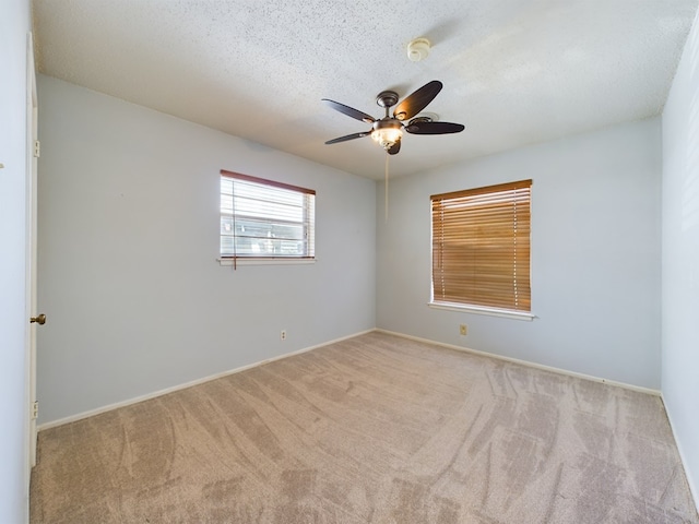 carpeted spare room featuring a textured ceiling and ceiling fan