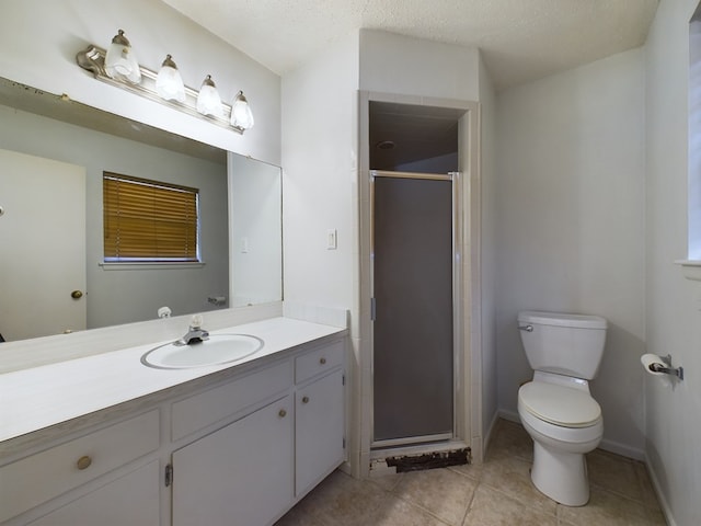 bathroom with vanity, a textured ceiling, a shower with door, tile patterned flooring, and toilet