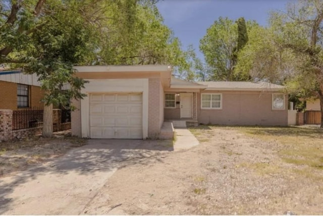 single story home featuring stucco siding, concrete driveway, and a garage