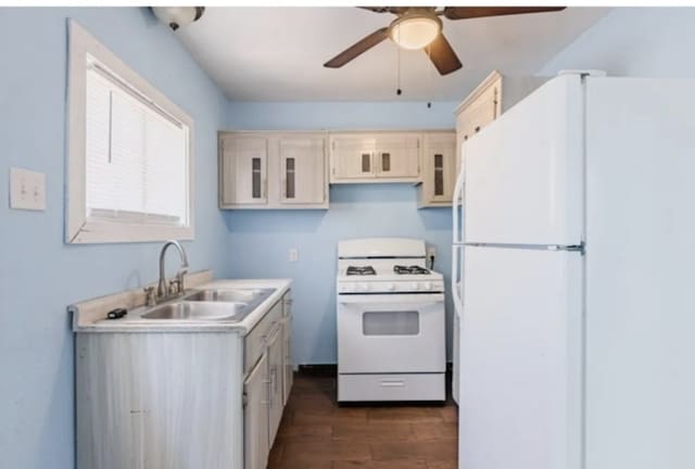 kitchen featuring white appliances, a ceiling fan, a sink, dark wood-type flooring, and light countertops