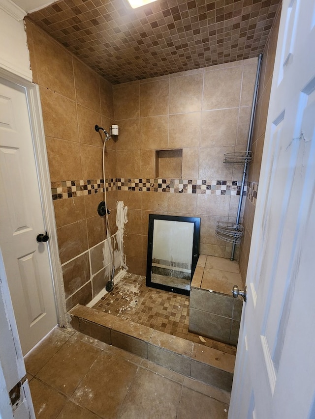 bathroom featuring tiled shower and tile walls