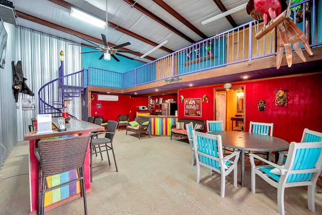 dining space with a wall unit AC, a ceiling fan, a high ceiling, metal wall, and stairs