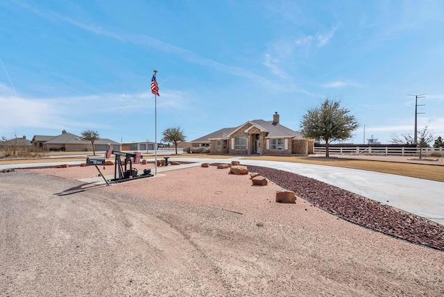 ranch-style home featuring a chimney and fence