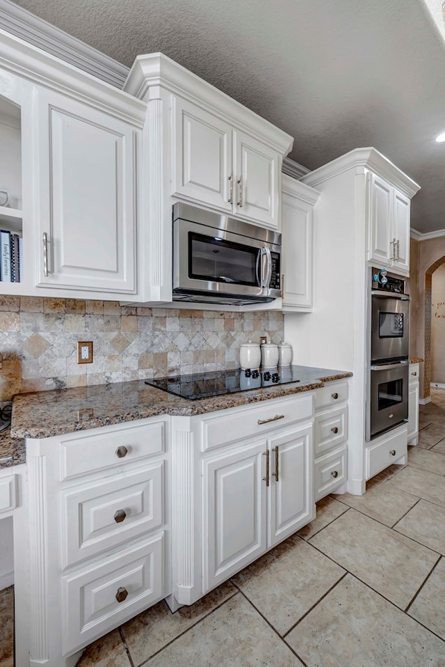 kitchen with white cabinets, stone countertops, and stainless steel appliances