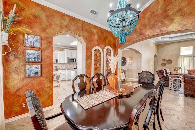 dining space with visible vents, a chandelier, ornamental molding, light tile patterned floors, and arched walkways